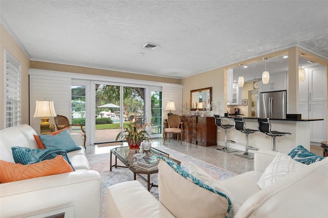 living room with a textured ceiling, light speckled floor, and visible vents