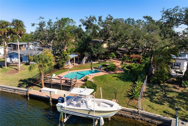 view of dock with an outdoor pool, a lawn, boat lift, a water view, and fence