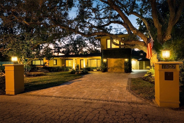 view of front of property with a garage and decorative driveway