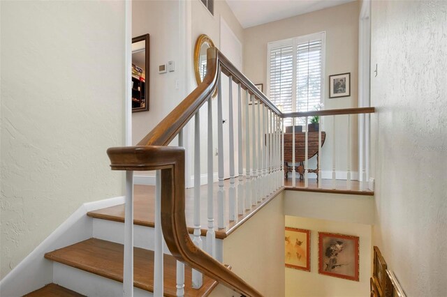 stairway with visible vents and a textured wall