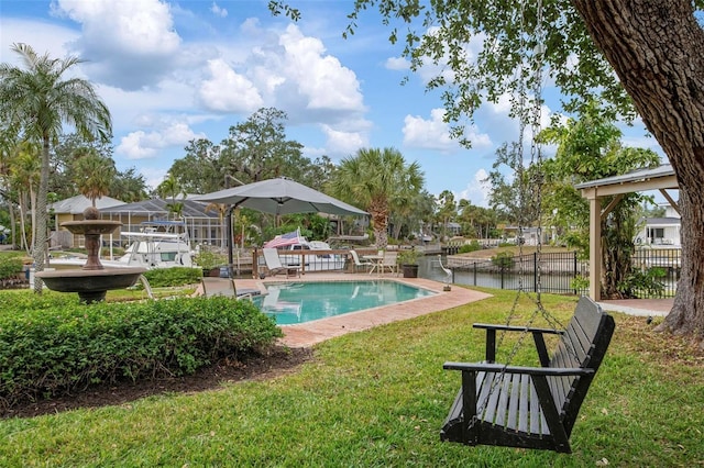 view of swimming pool featuring a water view, fence, a fenced in pool, and a yard