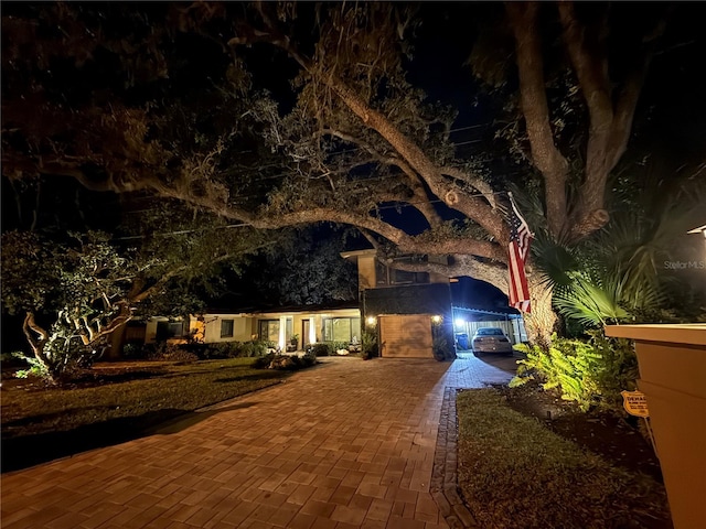 obstructed view of property with decorative driveway