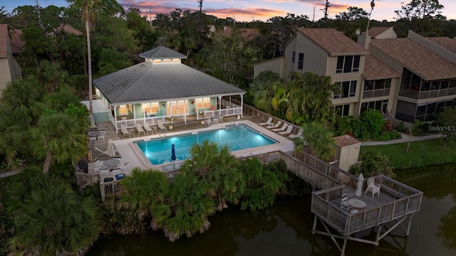 pool at dusk with a patio area