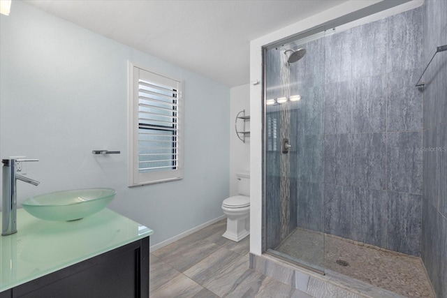 bathroom featuring vanity, toilet, and a tile shower