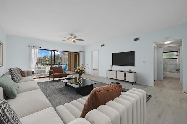 living room with ceiling fan and light hardwood / wood-style flooring