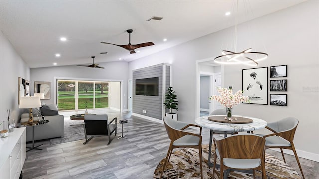 dining area featuring ceiling fan, wood-type flooring, and lofted ceiling