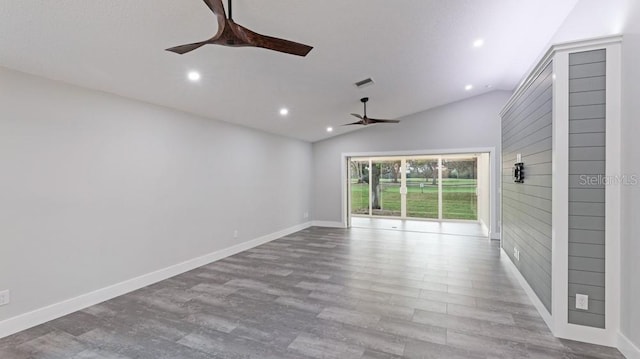 spare room featuring light wood-type flooring, vaulted ceiling, and ceiling fan