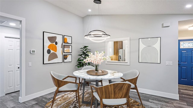 dining room featuring dark hardwood / wood-style floors and lofted ceiling