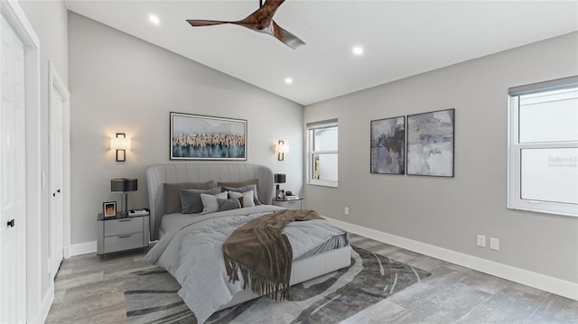 bedroom with ceiling fan, a closet, lofted ceiling, and light wood-type flooring