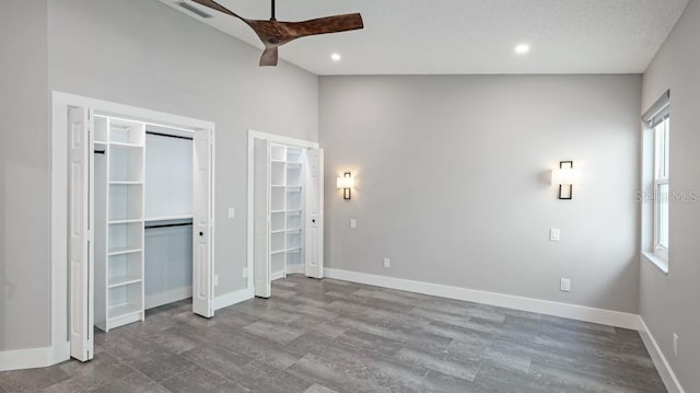 unfurnished bedroom with ceiling fan and high vaulted ceiling