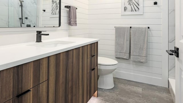 bathroom with wood walls, vanity, and toilet