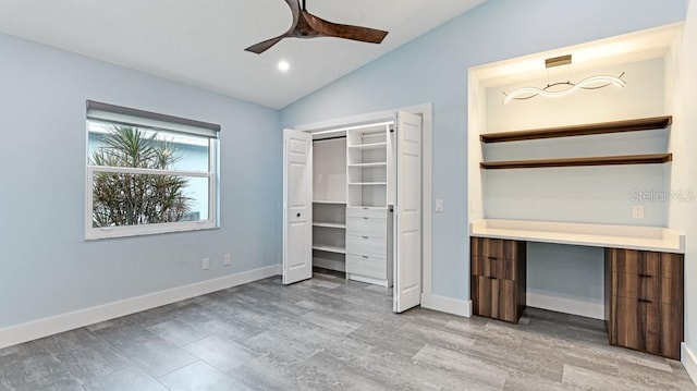 unfurnished bedroom with ceiling fan, a closet, lofted ceiling, and light hardwood / wood-style flooring