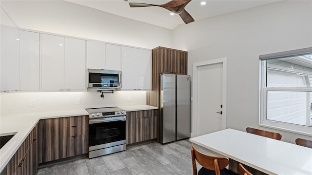 kitchen featuring dark brown cabinetry, stainless steel appliances, ceiling fan, light hardwood / wood-style floors, and white cabinetry