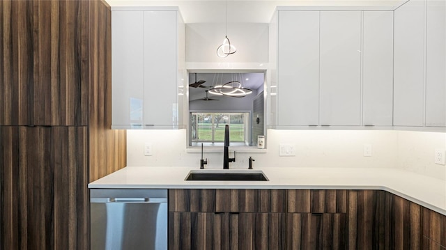 kitchen with dishwasher, sink, decorative backsplash, decorative light fixtures, and white cabinetry