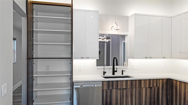 kitchen with dishwasher, white cabinets, pendant lighting, and sink