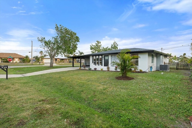 ranch-style home featuring a carport, central AC, and a front lawn