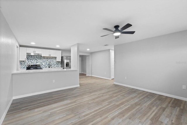 unfurnished living room with ceiling fan and light hardwood / wood-style floors