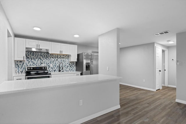 kitchen featuring decorative backsplash, appliances with stainless steel finishes, dark wood-type flooring, sink, and white cabinets