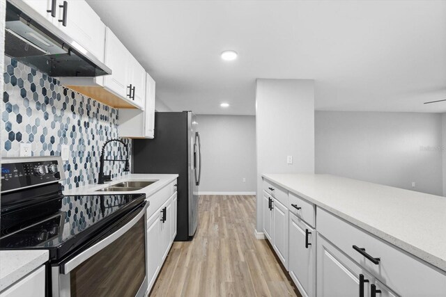 kitchen with tasteful backsplash, sink, white cabinets, light hardwood / wood-style floors, and black electric range oven