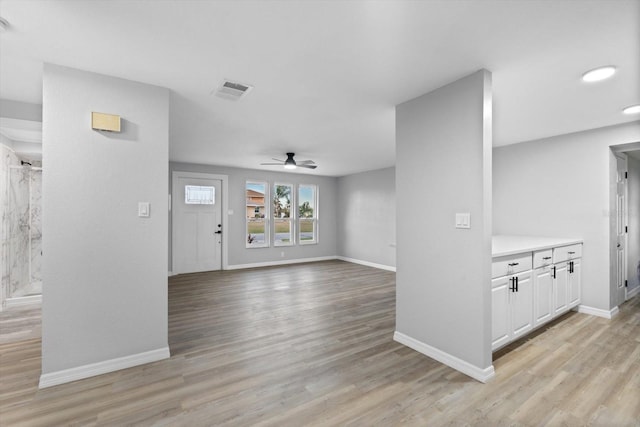 foyer entrance with ceiling fan and light wood-type flooring