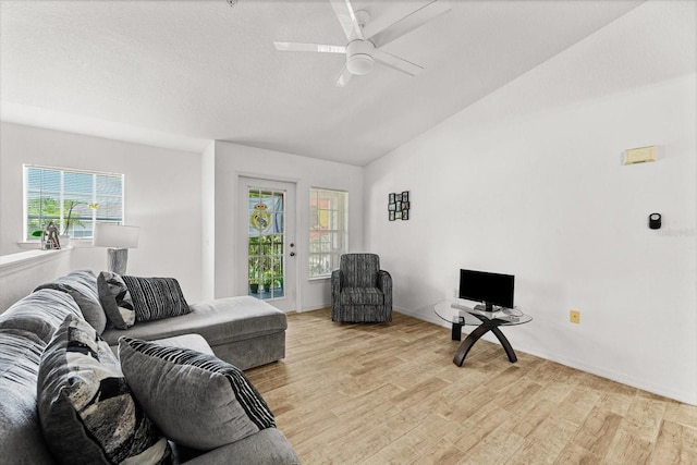 living room featuring ceiling fan, light wood-type flooring, and vaulted ceiling