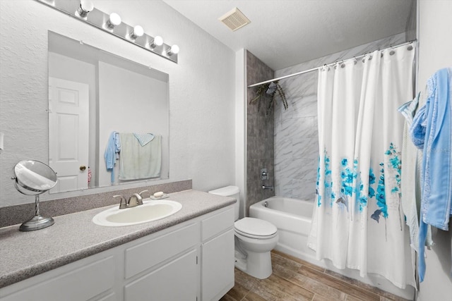 full bathroom with vanity, shower / bathtub combination with curtain, a textured ceiling, and toilet