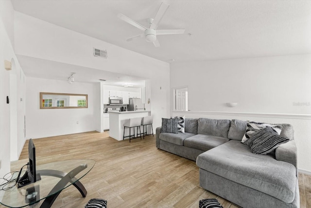 living room featuring light hardwood / wood-style flooring and ceiling fan