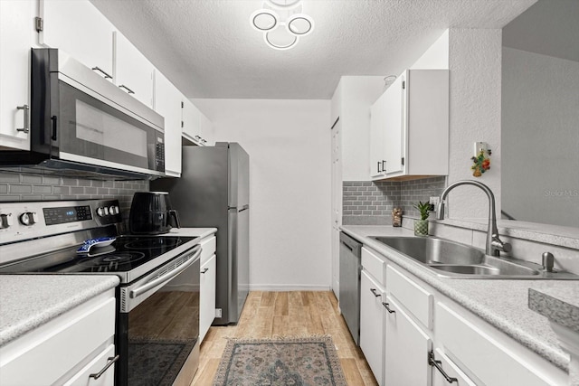 kitchen featuring white cabinets, sink, stainless steel appliances, and tasteful backsplash