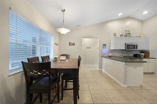 tiled dining area featuring lofted ceiling