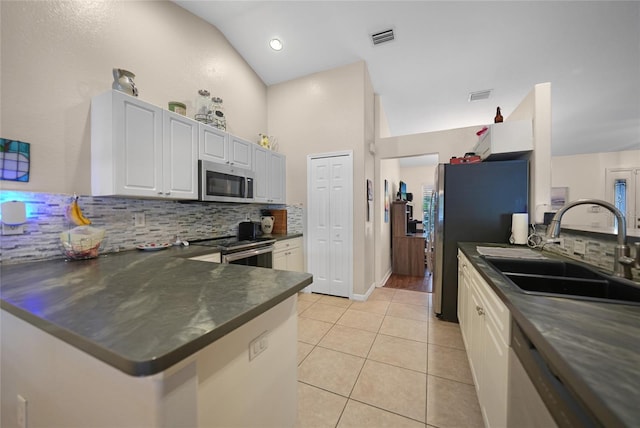 kitchen featuring white cabinets, sink, vaulted ceiling, kitchen peninsula, and stainless steel appliances