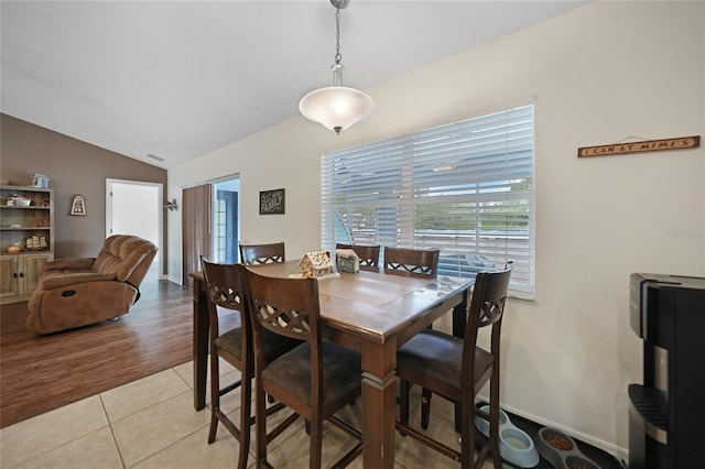 dining room with vaulted ceiling and light tile patterned flooring