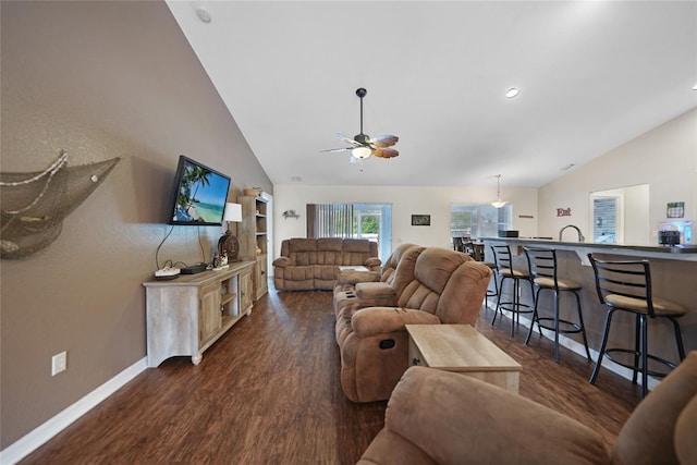 living room with ceiling fan, lofted ceiling, and dark wood-type flooring