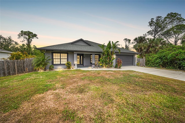 view of front of home with a garage and a lawn