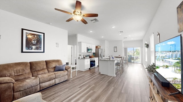 living room featuring light hardwood / wood-style floors and ceiling fan