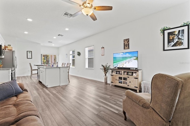 living room featuring ceiling fan and light wood-type flooring