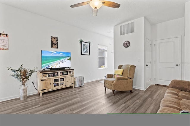 sitting room with hardwood / wood-style floors and ceiling fan