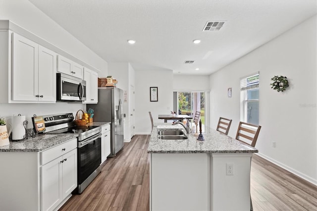 kitchen featuring white cabinetry, sink, an island with sink, and appliances with stainless steel finishes