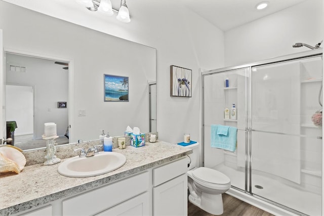 bathroom featuring toilet, vanity, an enclosed shower, and hardwood / wood-style flooring