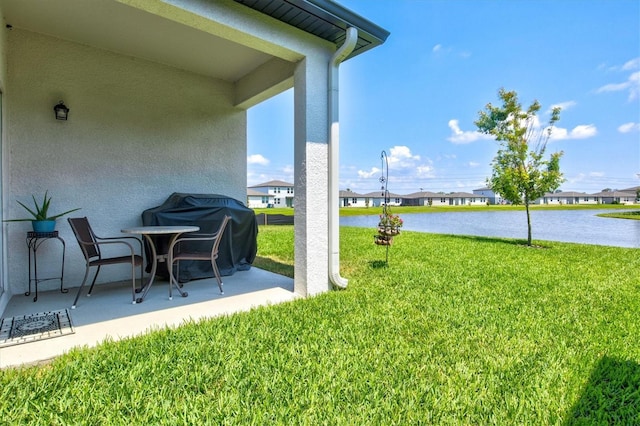 view of yard featuring a water view and a patio