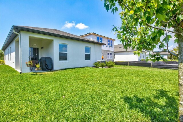 rear view of property with a yard