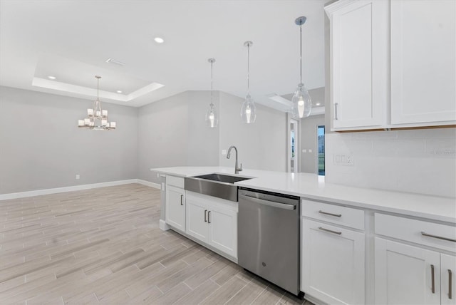 kitchen featuring sink, hanging light fixtures, stainless steel dishwasher, a tray ceiling, and white cabinets