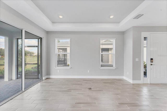 entrance foyer featuring a tray ceiling and a wealth of natural light