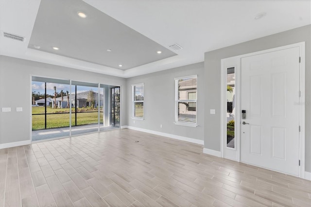 foyer entrance with a raised ceiling