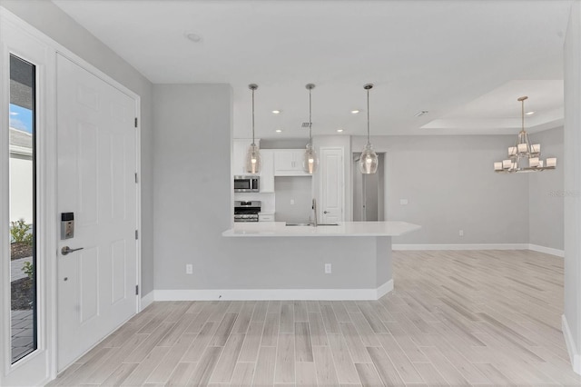 kitchen featuring white cabinets, decorative light fixtures, plenty of natural light, and stainless steel appliances