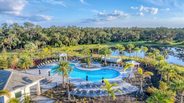 view of swimming pool featuring a water view and a patio