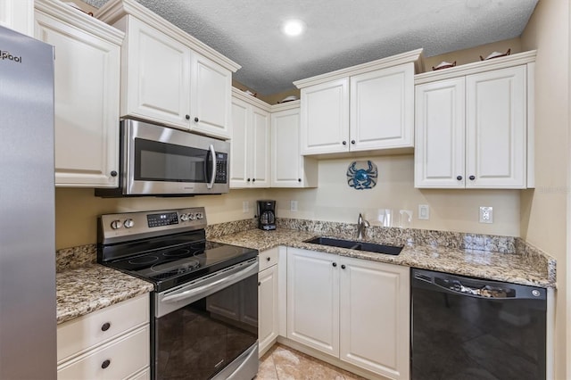 kitchen with white cabinets, sink, appliances with stainless steel finishes, and a textured ceiling