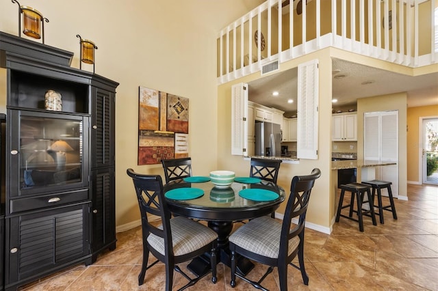 dining area featuring a towering ceiling