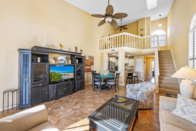 living room featuring a towering ceiling and ceiling fan