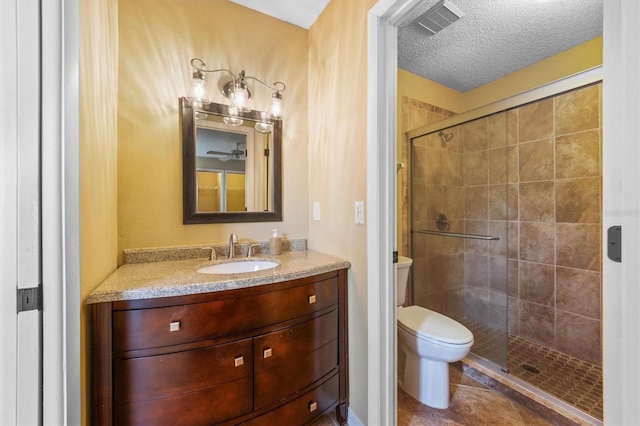 bathroom featuring tile patterned flooring, a textured ceiling, toilet, vanity, and a shower with shower door