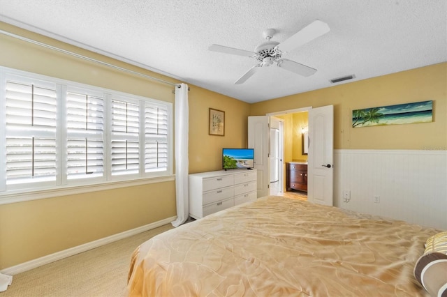 carpeted bedroom featuring ceiling fan and a textured ceiling